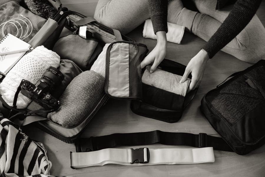 Travel gear laid out beside a packed bag