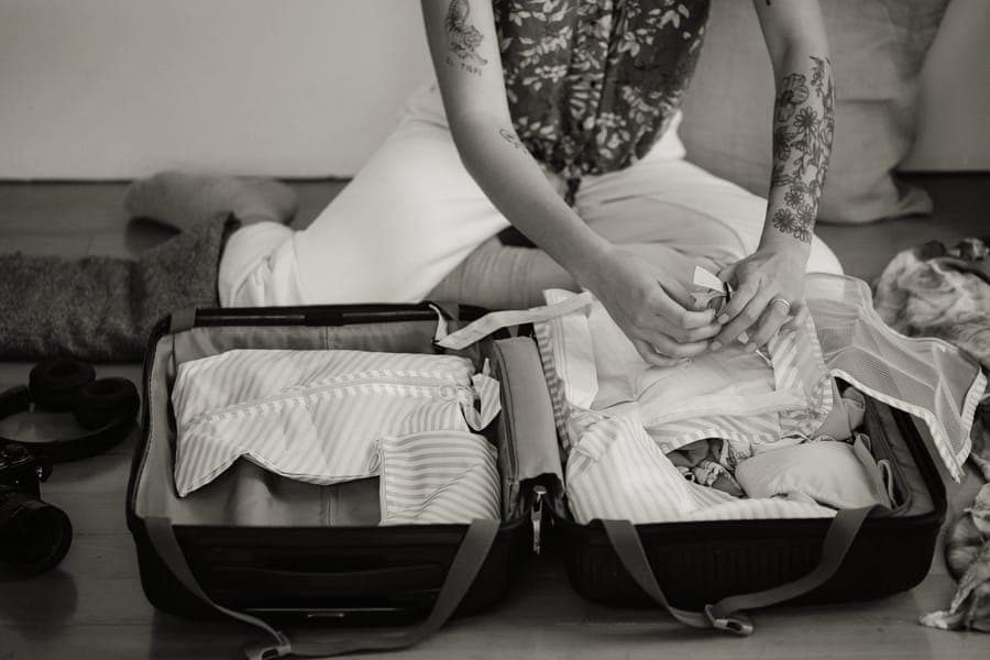 Travel items laid out beside a packed bag