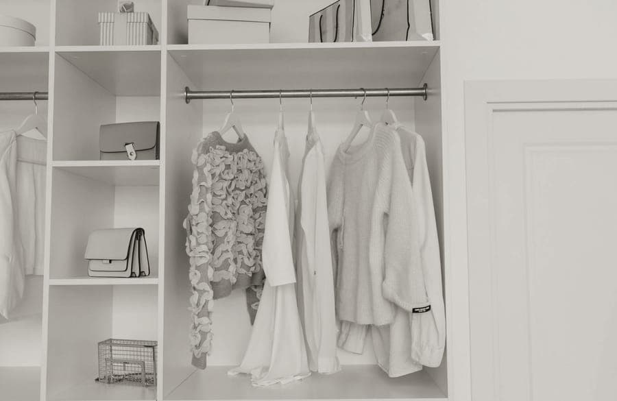 Shirts and a jacket hanging on a wardrobe rail