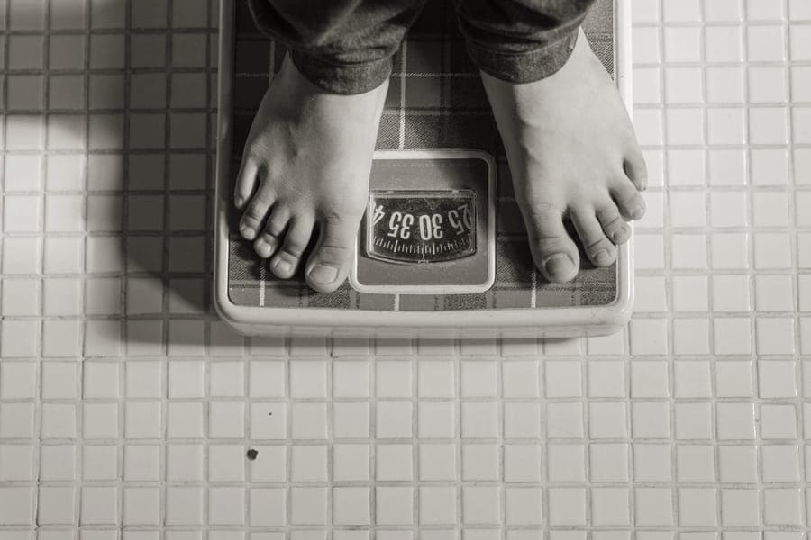 A handheld digital luggage scale hooked to a suitcase handle