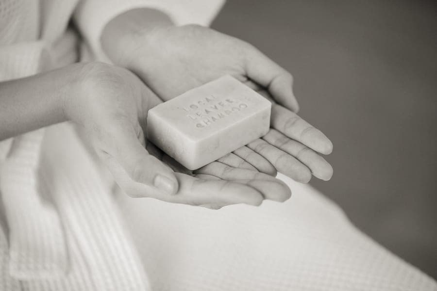 Solid shampoo and soap bars on a stone surface