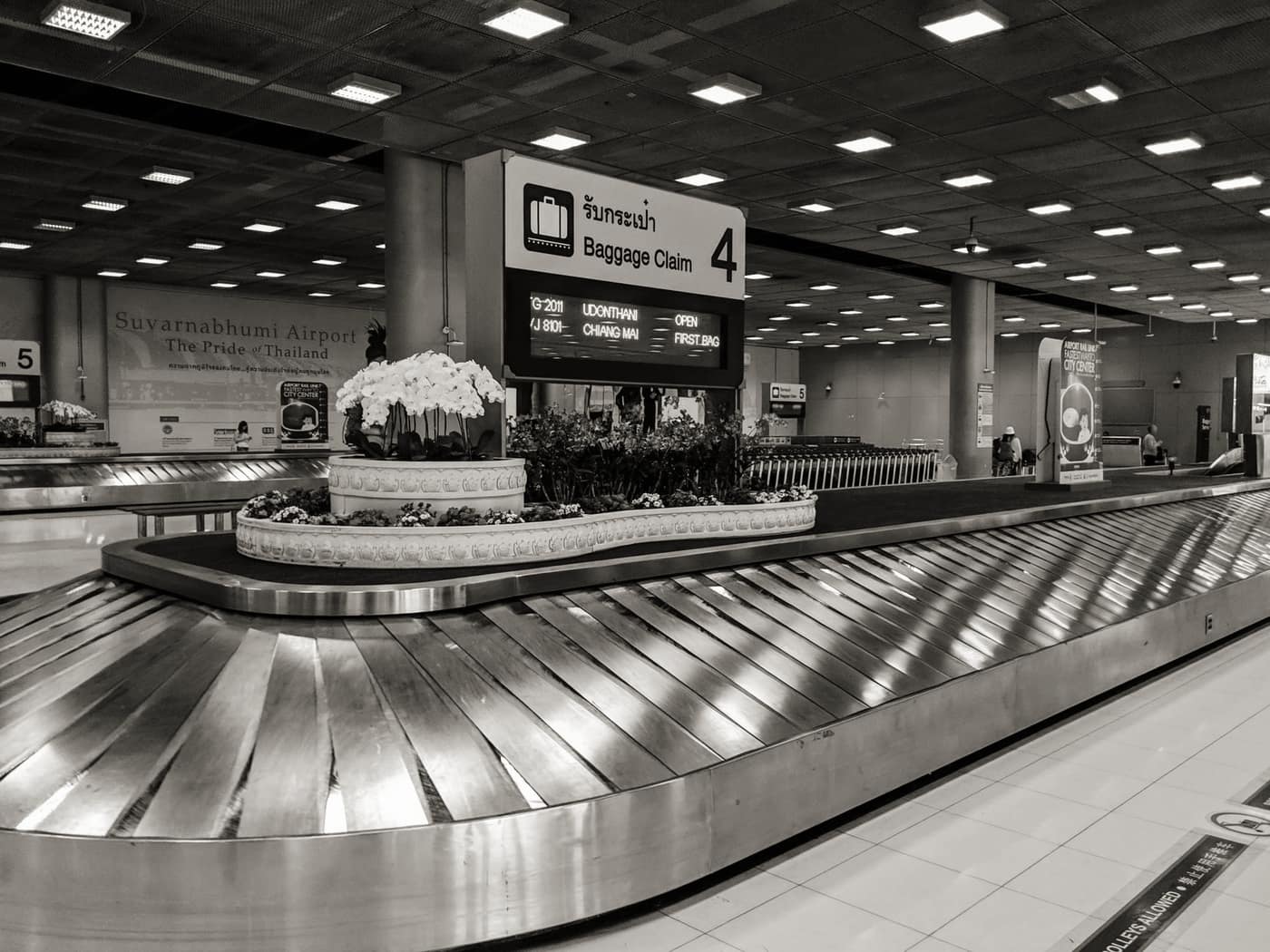 Suitcases circling a baggage claim carousel in an airport arrivals hall