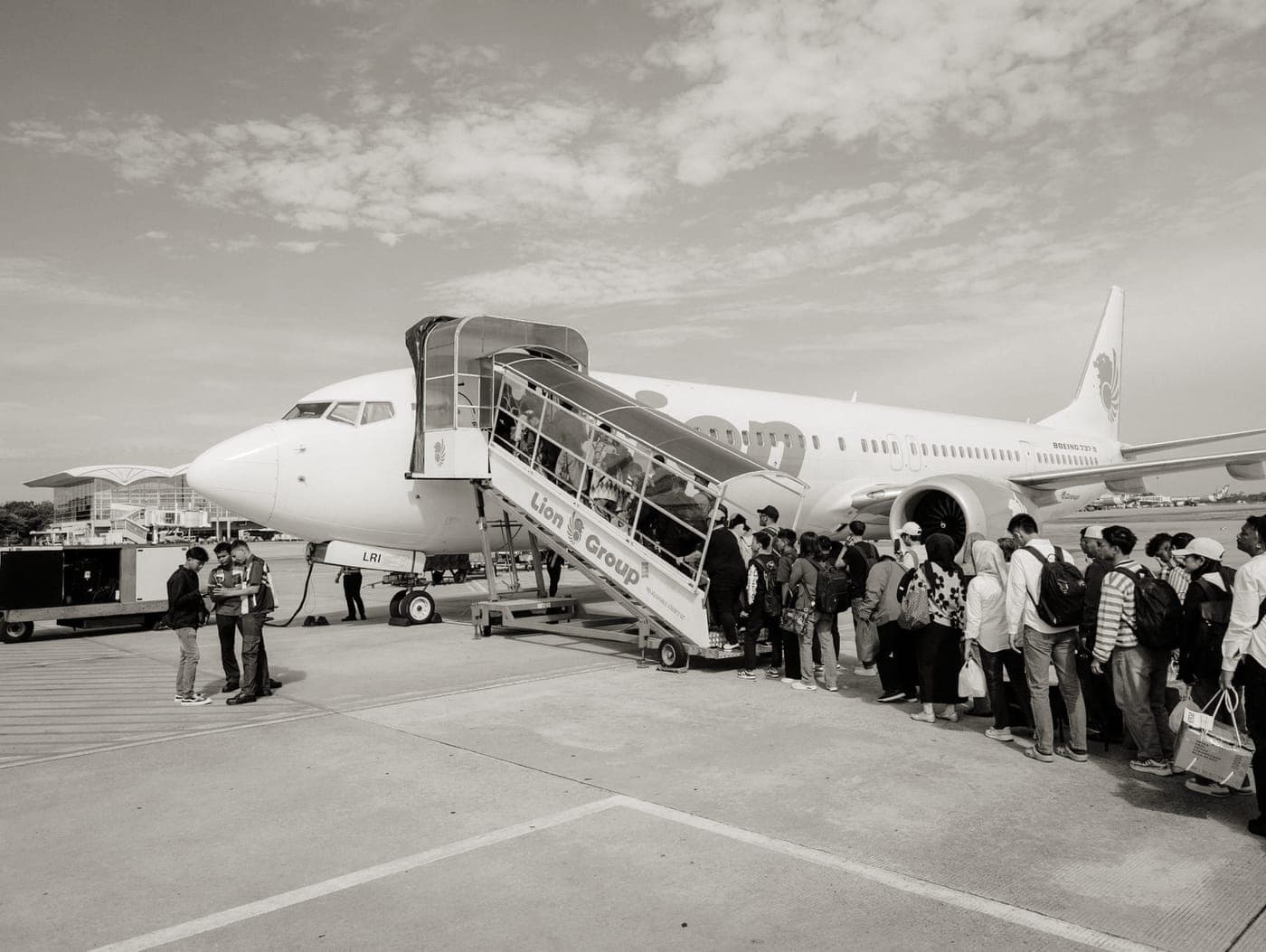 Passengers waiting with bags at an airport boarding gate