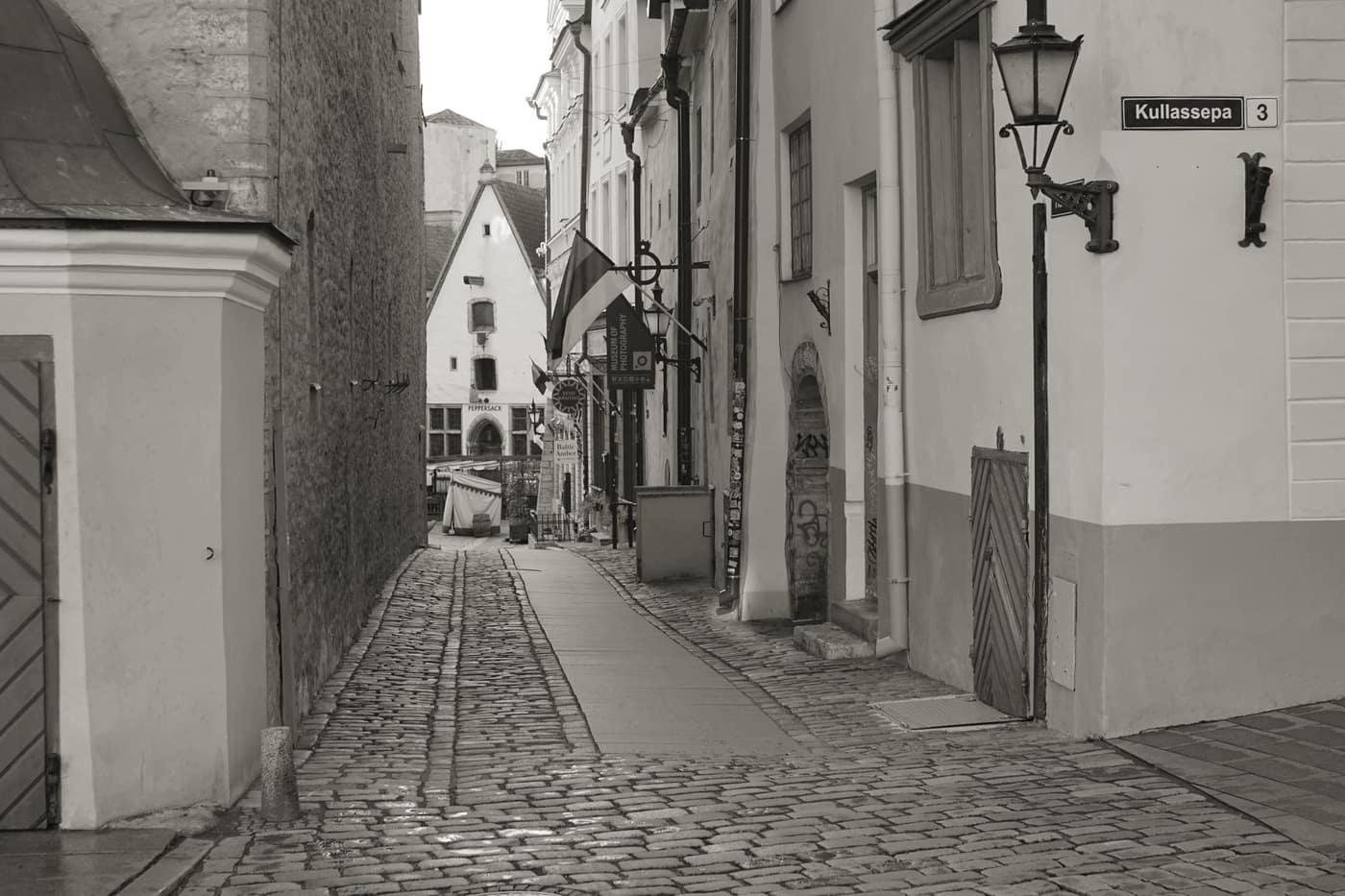 A narrow street in a European city with people walking