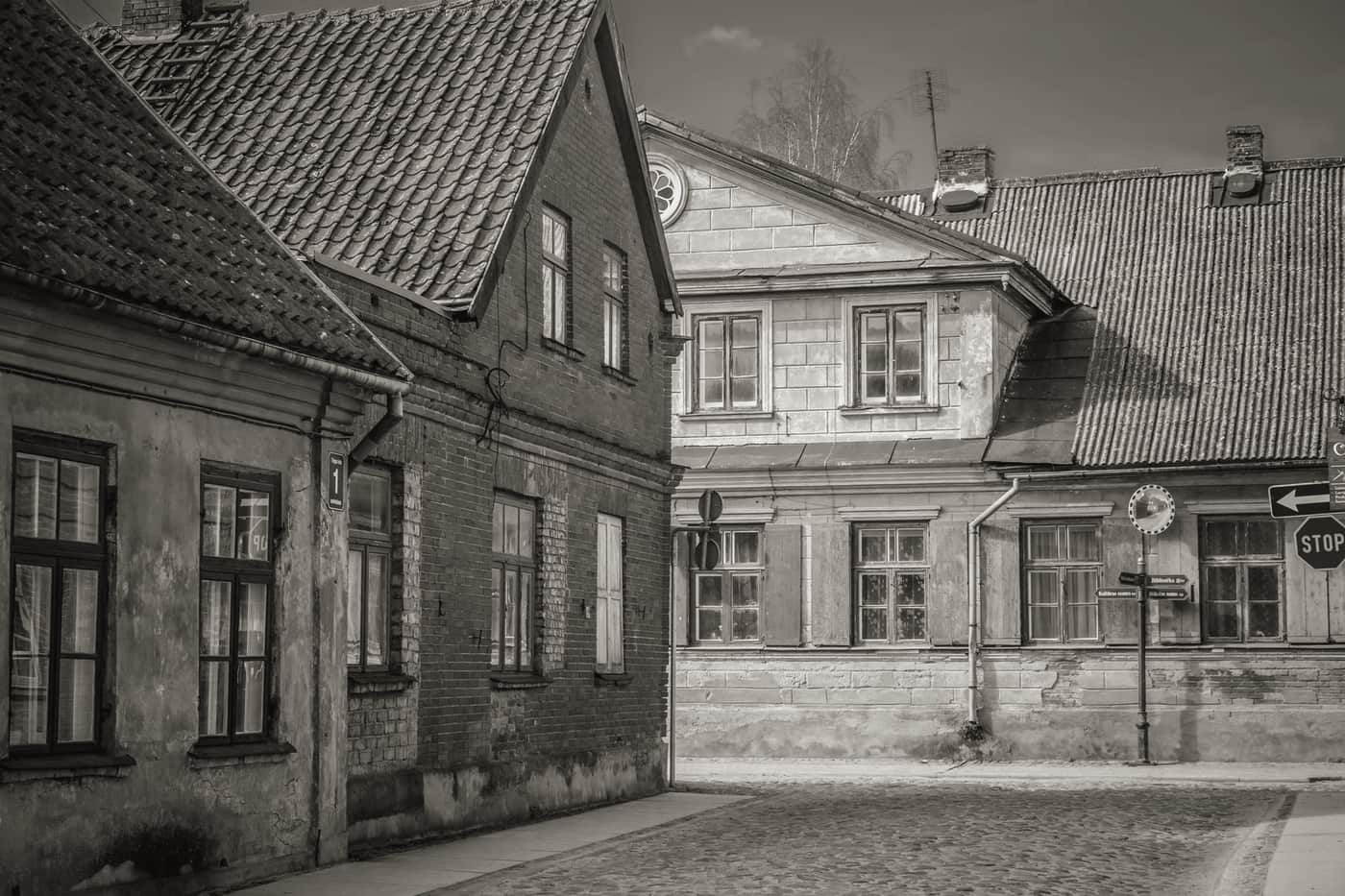 A wheeled suitcase being pulled across cobblestones in an old town street