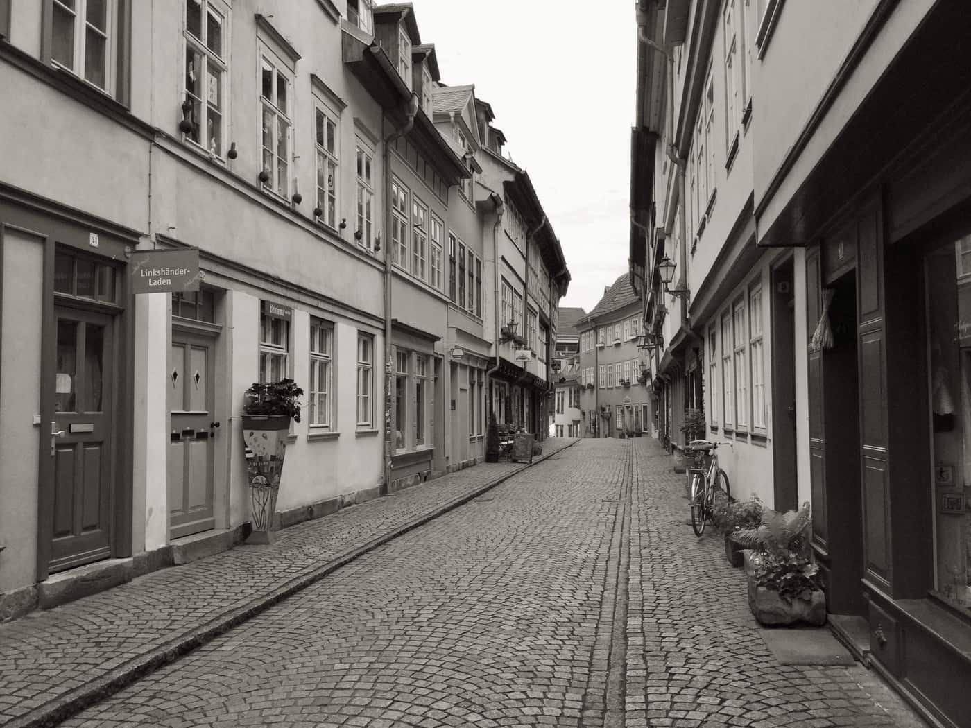 A quiet cobbled European street lined with old townhouses