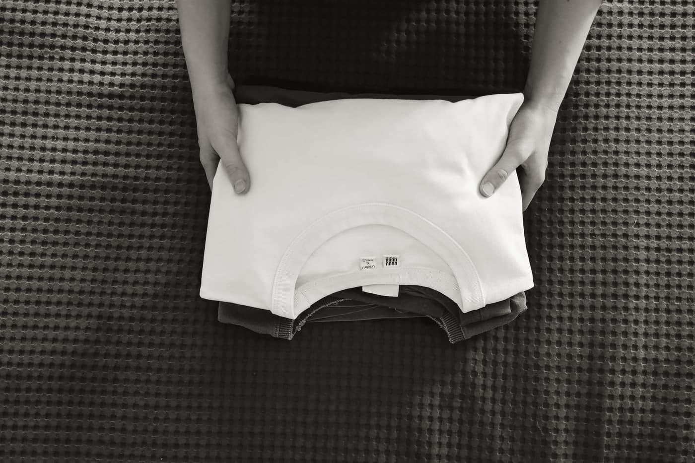Clothes being folded and packed into an open cabin suitcase
