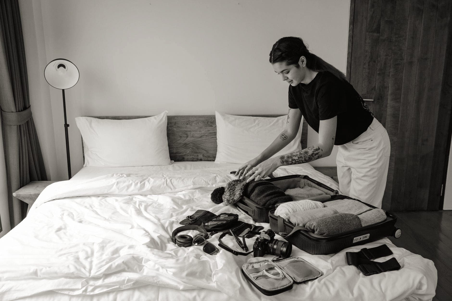 Travel gear and a packed bag arranged on a bed