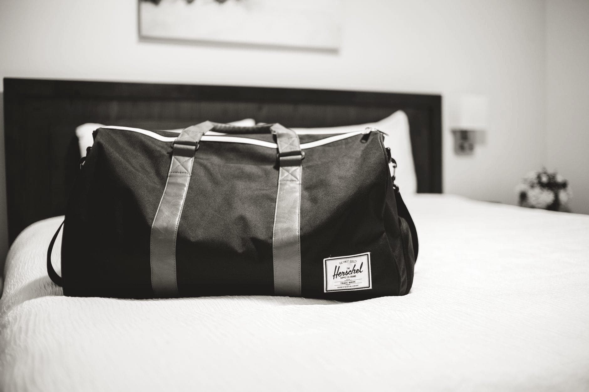 A part-packed cabin suitcase on a bed with folded clothes beside it