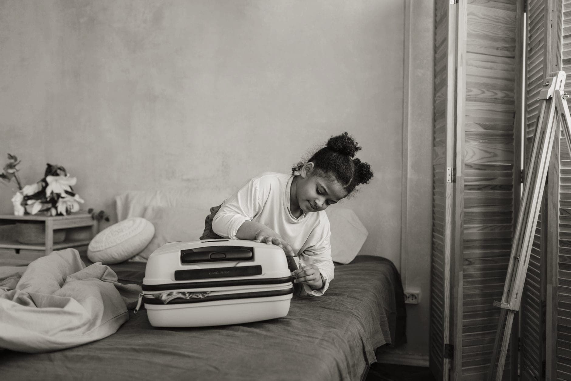 An open suitcase packed with clothes and travel items on a bed