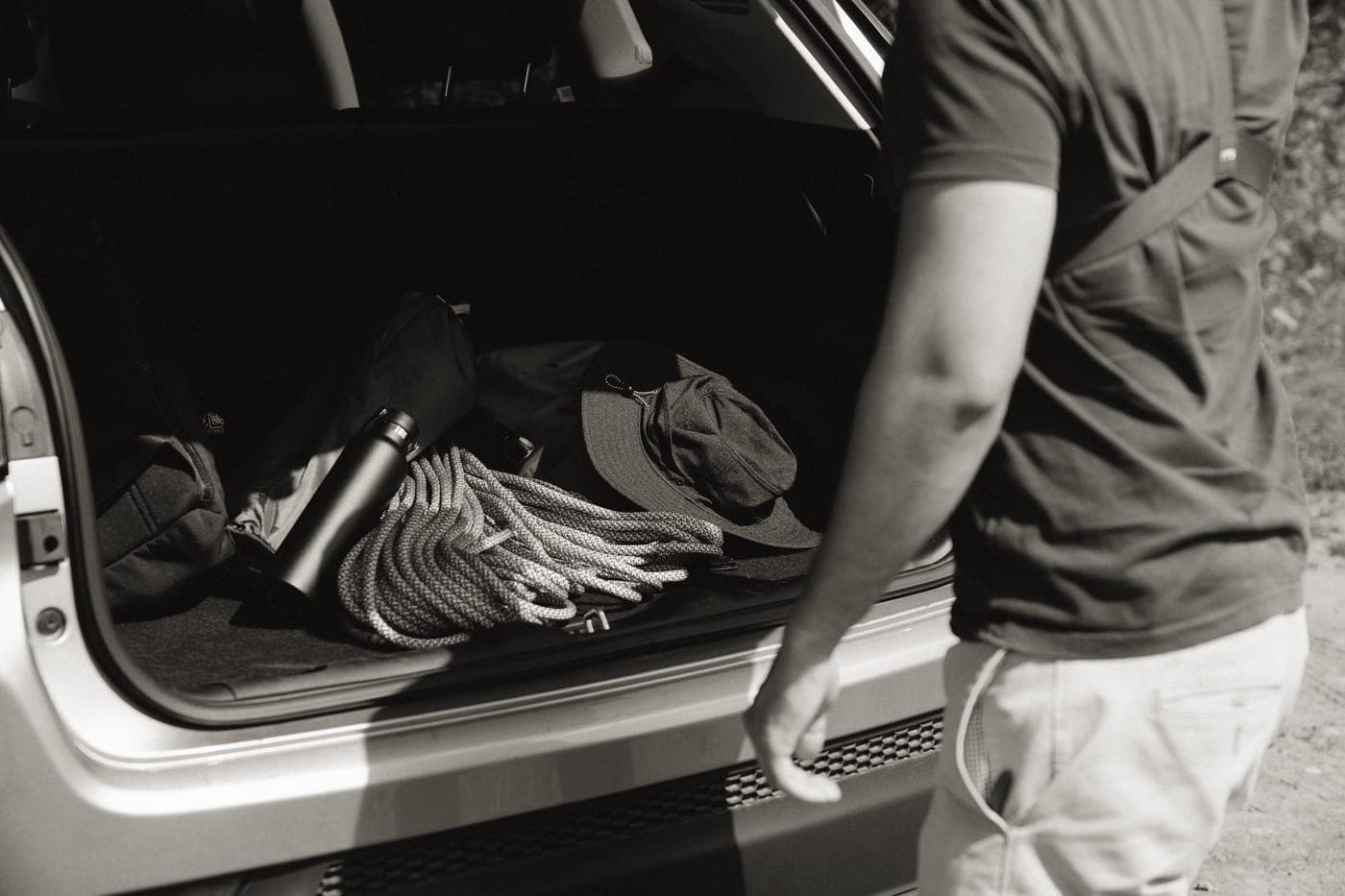 A wheeled duffel bag being loaded into a vehicle